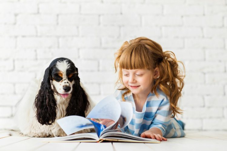 絵本を読む少女と犬