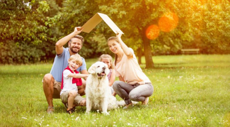 家族と犬が芝生で写真を撮っている様子